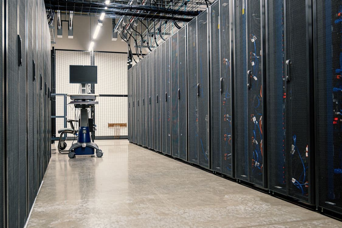 An aisle between rows of server racks in a data center